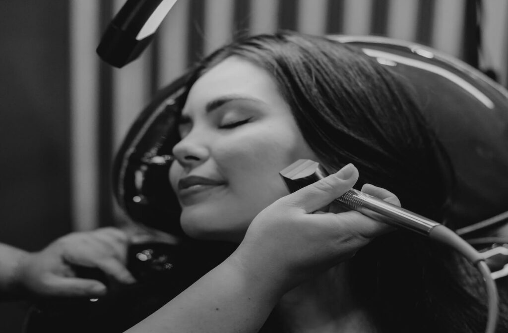 A young woman smiles while she receives a radiofrequency treatment