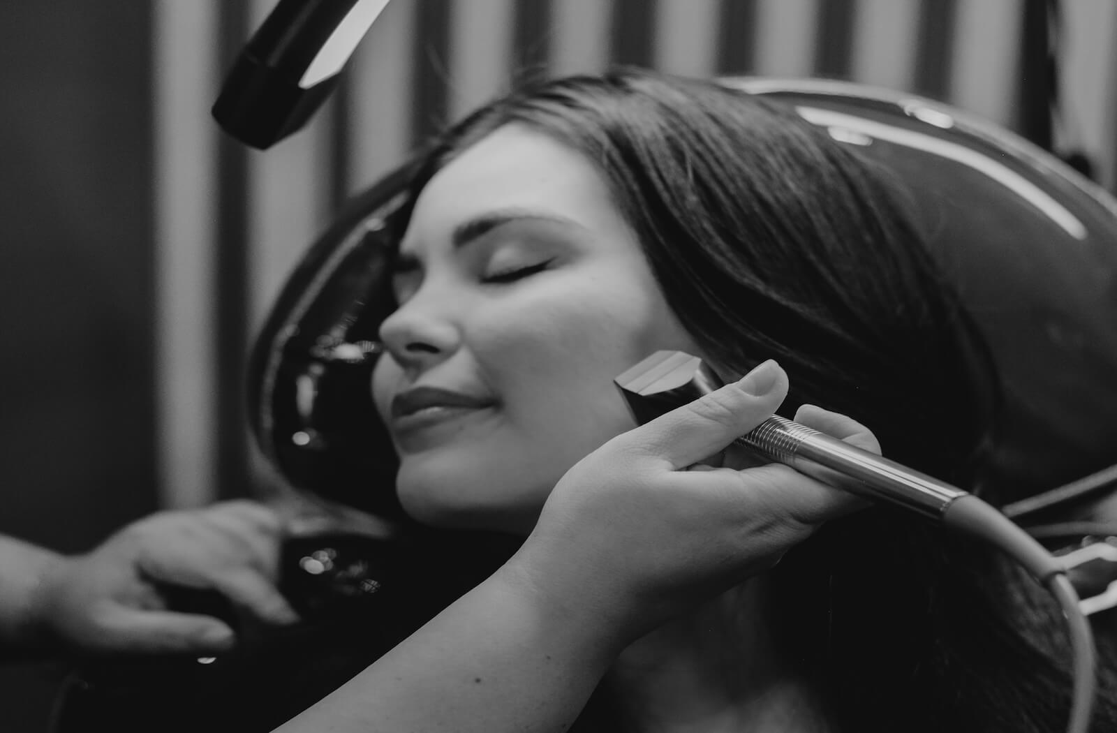 A young woman smiles while she receives a radiofrequency treatment